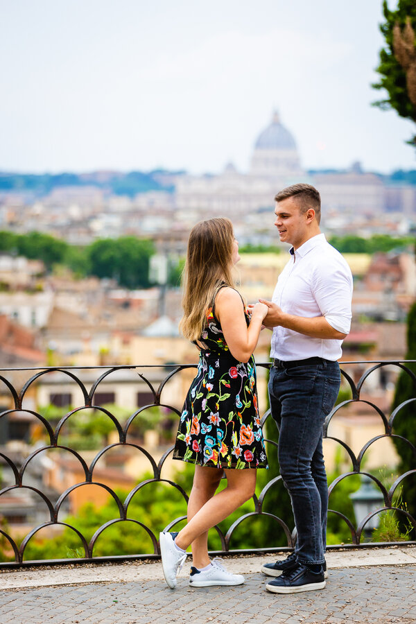 Couple holding hands on the Terrazza Belvedere with the Vatican in the background