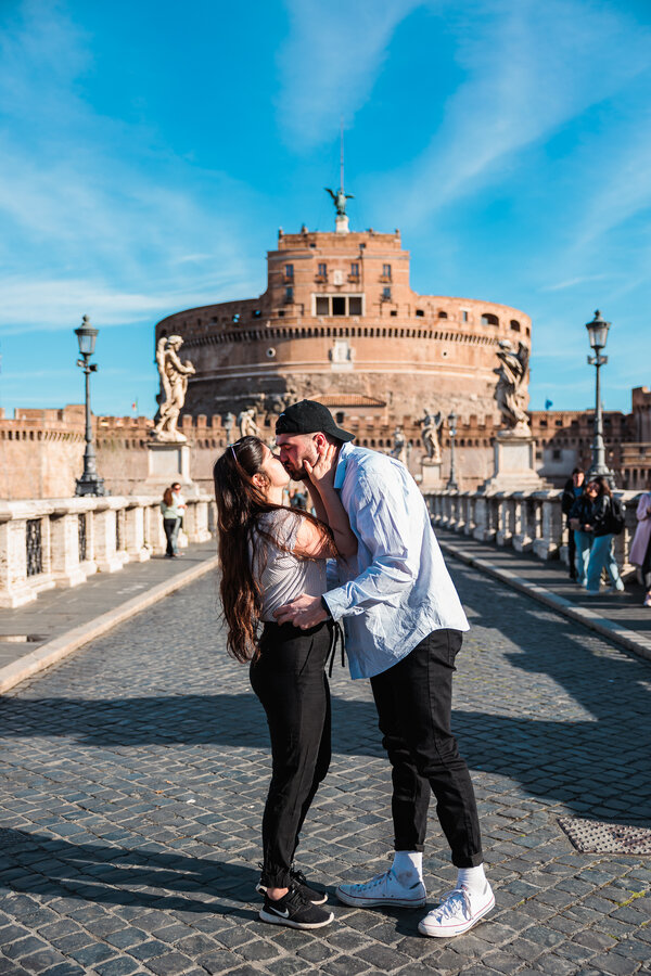 Newly-engaged couple kissing passionately during their surprise wedding proposal photo session in Rome