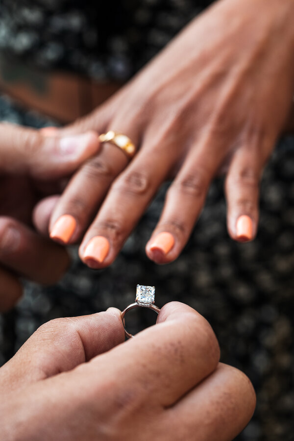 Close-up picture of dazzling diamond ring before reaching the fiancée's finger