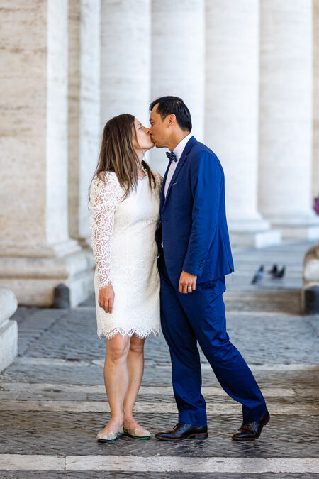 Newly-weds Sposi Novelli kissing under St. Peter's Square Colonnade