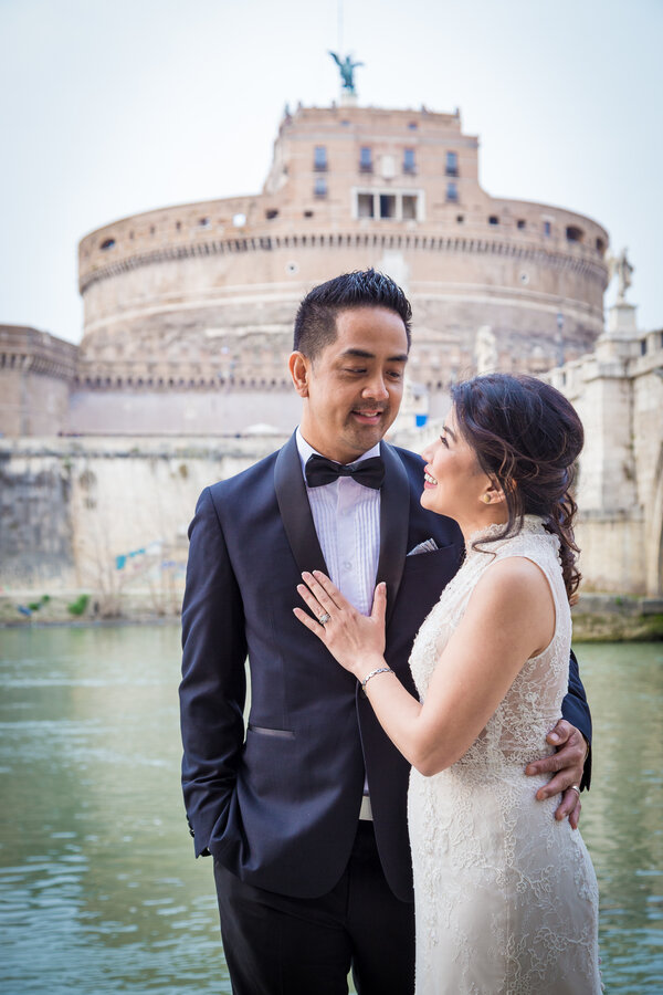 Iconic portrait of a beautiful newly-wed couple during a Sposi Novelli photo session with Castel Sant'Angelo in the background, Rome