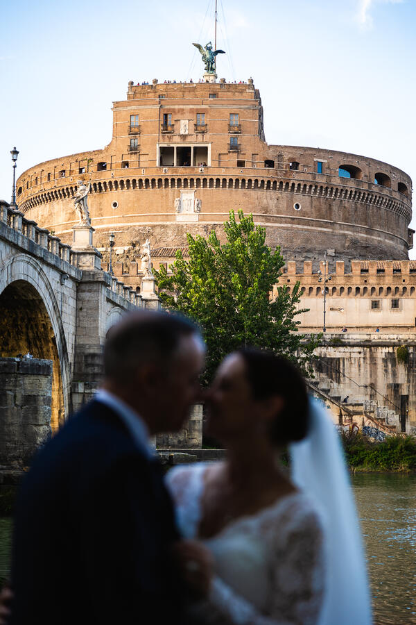Sposi Novelli couple intimate moment with Castel Sant'Angelo in the background