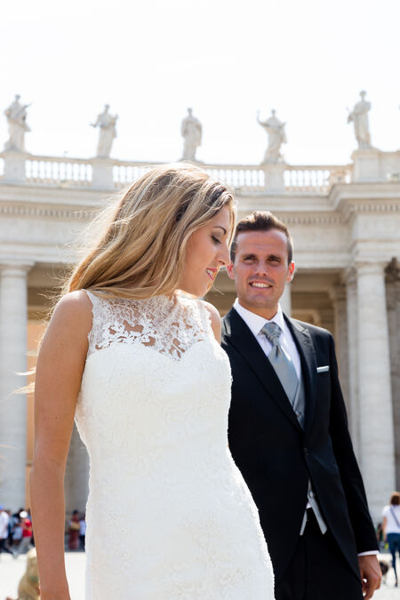 Sposi Novelli holding hands in St Peter's Square during a wedding photo session