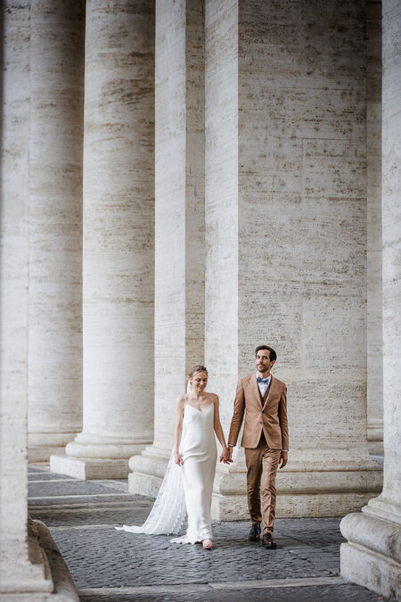 Sposi Novelli couple holding hands under the Saint Peter's Square Colonnade