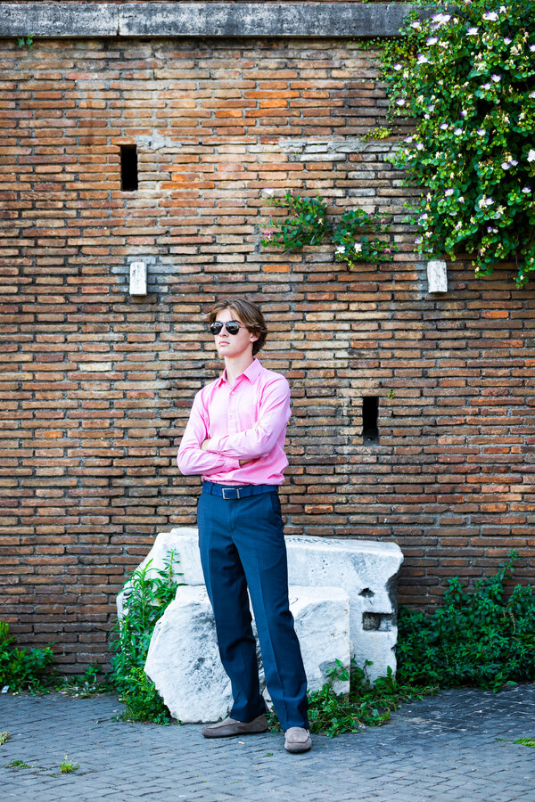Boy standing and posing for the camera during his senior photoshoot in Rome
