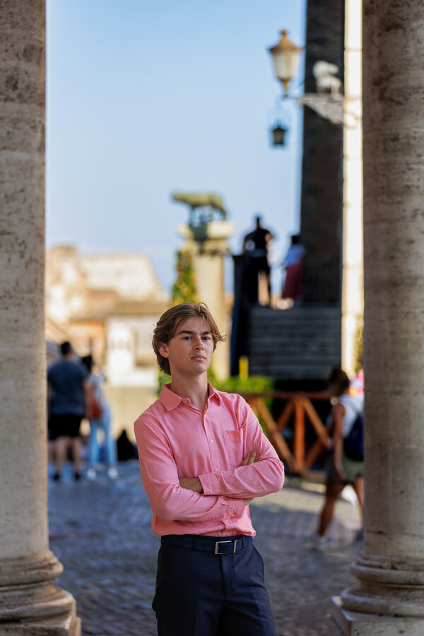 Boy on the Capitoline Hill with the she-wolf nursing twins in the background during his senior photo shoot in Rome