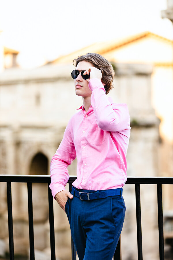 Boy posing on the terrace overlooking the Roman Forum during his senior photo shoot in Rome