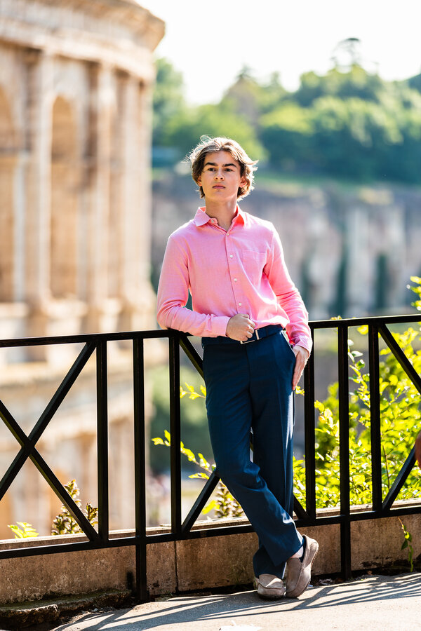 Young boy posing for the camera during his senior photo session in Rome with the Colosseum in the background