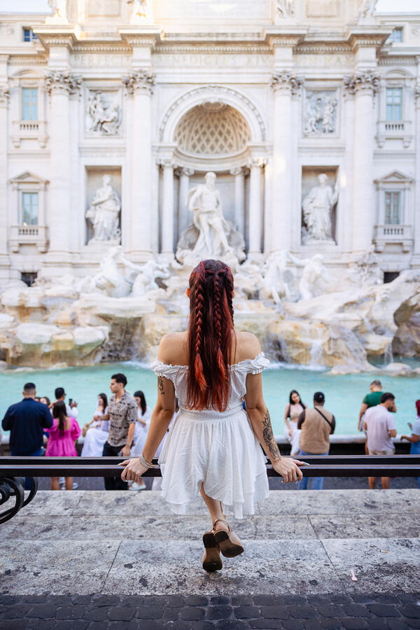 Girl sitting facing the Trevi Fountain during her Solo Traveler Photoshoot in Rome