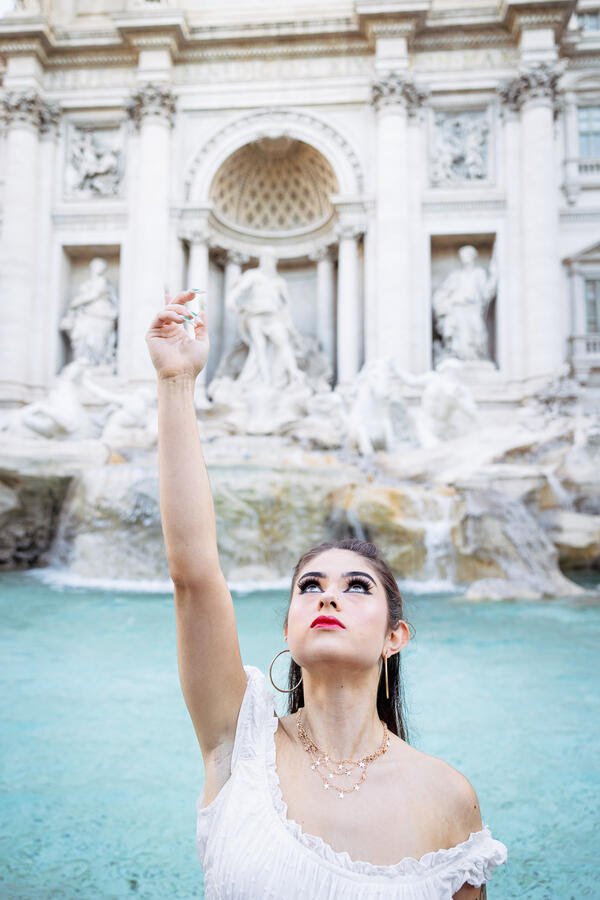 Girl tossing a coin into the Trevi Fountain during her Solo Traveller Photoshoot in Rome