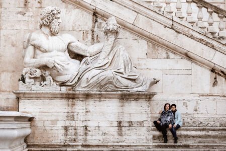 Mother and daughter next to the Tiber River Statue on the Capitoline HIll during a family photo sessionin Rome