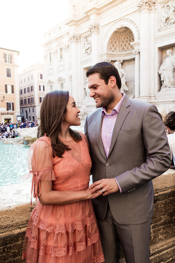 Elegant couple holding hands at the Trevi Fountain Rome during a vacation photo shoot