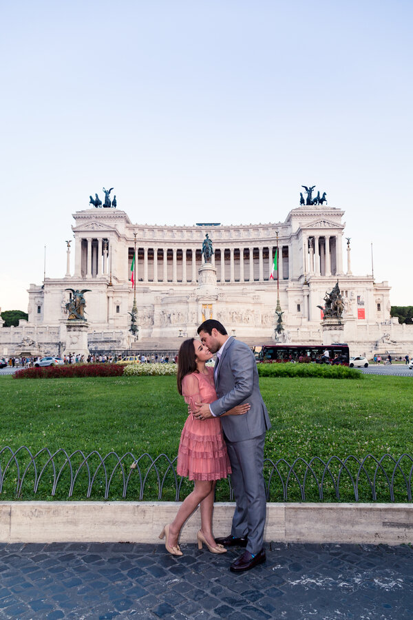 Iconic portrait of couple kissing in Piazza Venezia with the Vittoriano in the background
