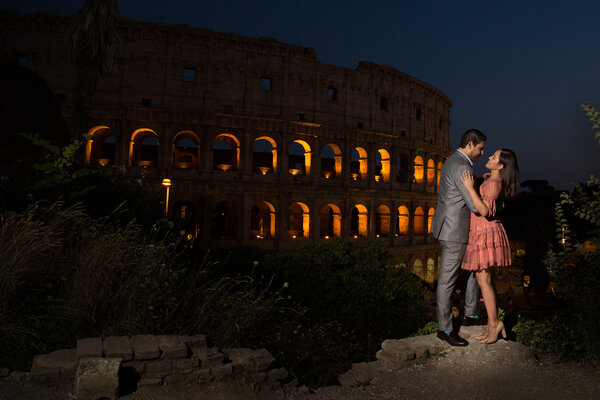 Night portrait of elegant couple with the Colosseum in the background, during their vacatino photo session in Rome