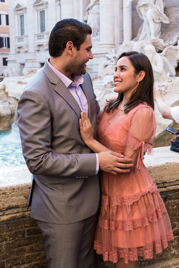 Elegant couple smiling at each other at the Trevi Fountain