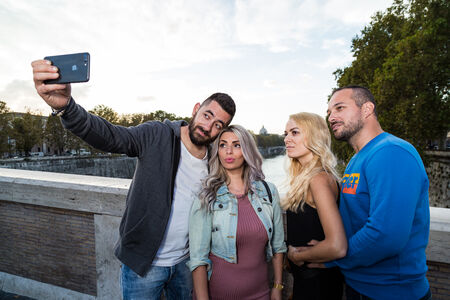 Friends taking a selfie at the end of their vacation photo session on the Ponte Sisto in Rome
