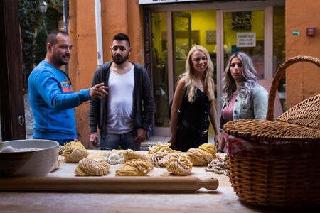 Friends stopping by a restraurant to look at fresh pasta in Trastevere Rome