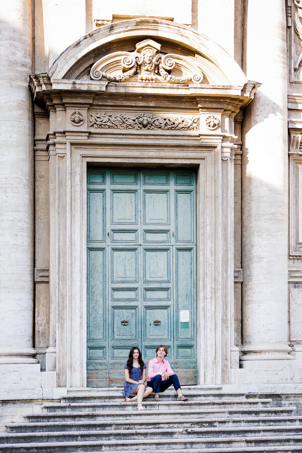 Son and daughter sitting down at the top of a church stairs during a family photoshoot in Rome