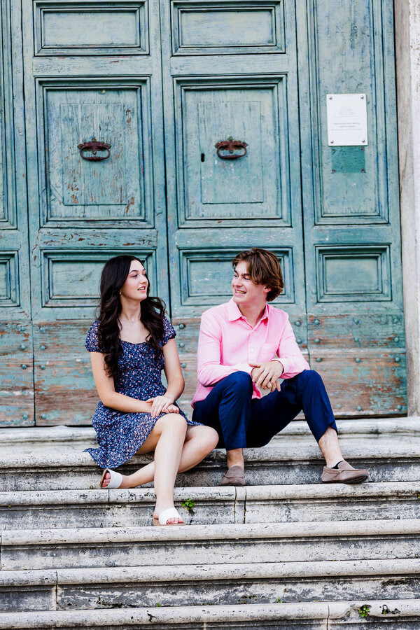 Son and daughter smiling while sitting down at the top of church stairs in Rome