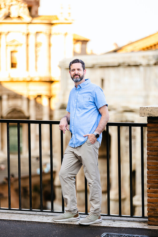 Father posing on the Roman Forum overlook during a family photo session in Rome