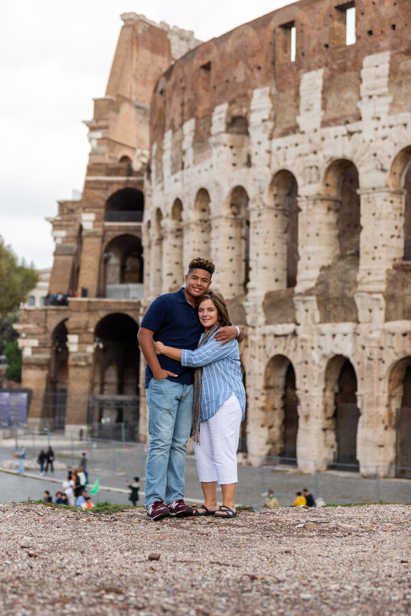 Sweet embrace of mother and son at the Colosseum in Rome