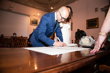 Groom signing the wedding papers during a civil ceremony