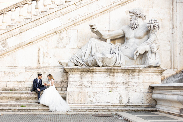 Wedding couple sitting at the foot of the Nile River God Statue on the Capitoline Hill