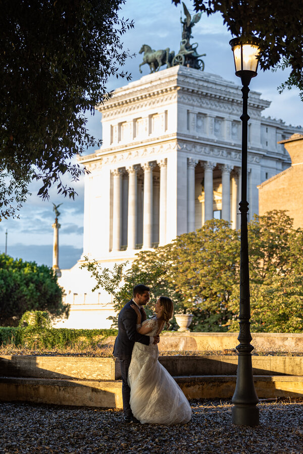 Bride and groom holding each other at the Terrazza Caffarelli with the Vittoriano in the background