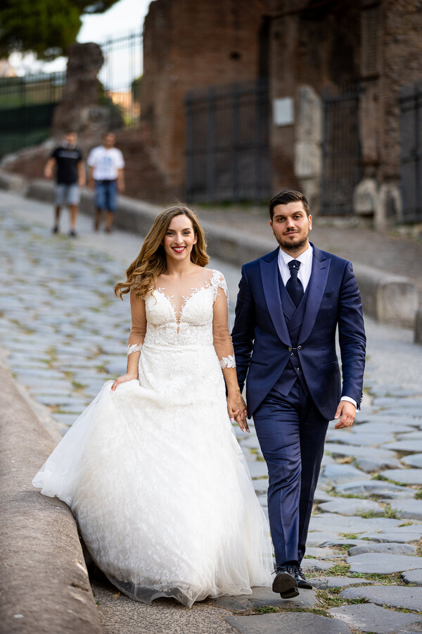 Beautiful wedding couple walking hand in hand in the heart of the Eternal City