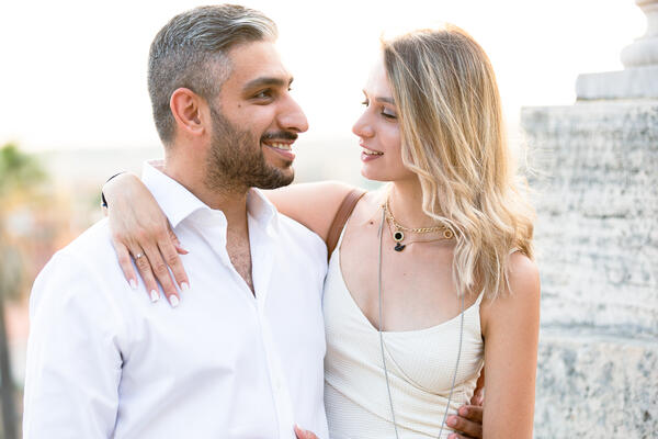 Newly-engaged couple smiling at each other during their surprise proposal in Rome