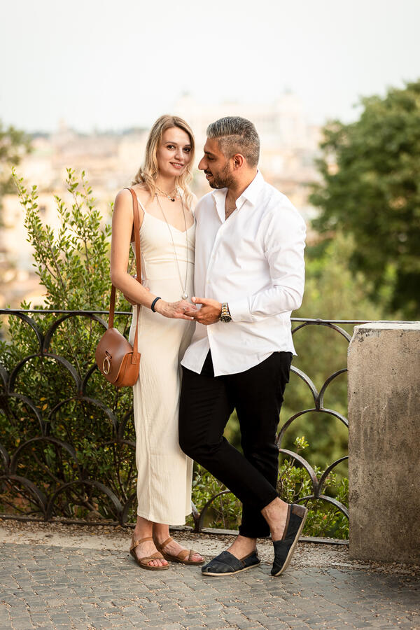 Newly-engaged couple holding hands on the Terrazza Belvedere at sunset
