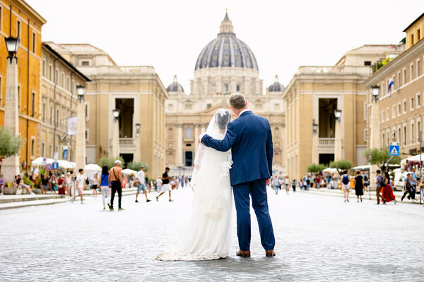 Couple from behind looking at Saint Peter's in Via della Conciliazione in Rome