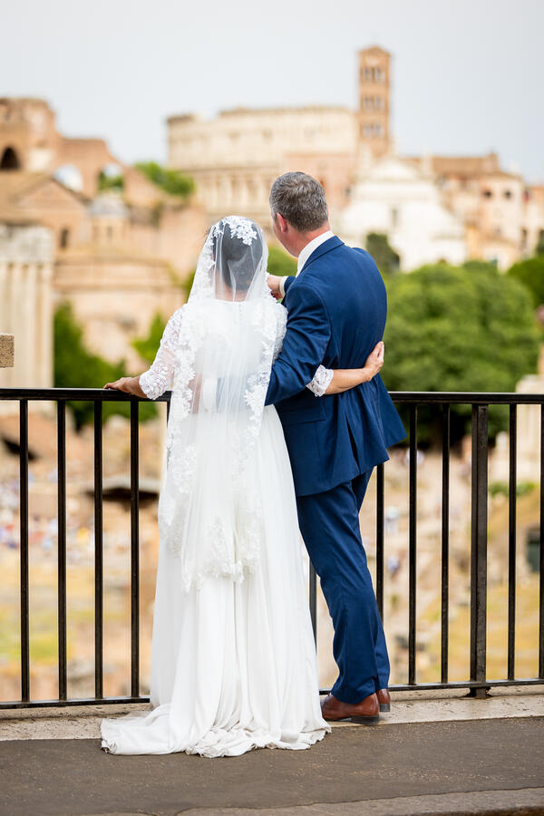 Sposi Novelli couple at the Roman Forum lookout on the Capitoline Hill looking at the Colosseum