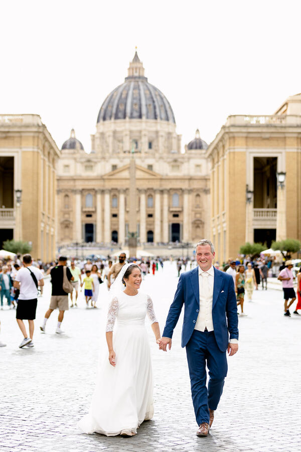 Happy Sposi Novelli couple walking along Via della Conciliazione with Saint Peter's in the background